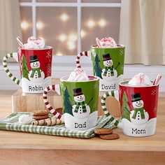 coffee mugs decorated with candy canes and marshmallows