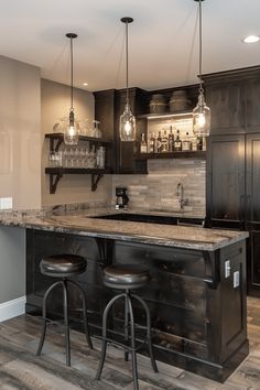 a kitchen with two bar stools next to an island in the middle of it