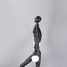 a statue is shown in front of a gray background with two lights on it's sides