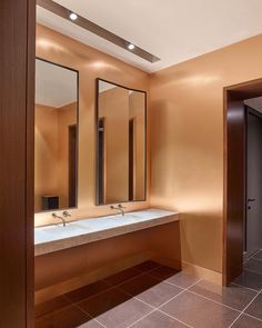 an empty bathroom with two sinks and mirrors