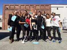 a group of people standing next to each other in front of a brick building with blue sticky notes on it