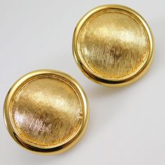 two gold colored buttons on a white surface