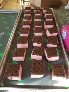 some pink and brown ice cream sandwiches on a tray