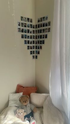 there is a teddy bear on the bed in this room with many pictures on the wall