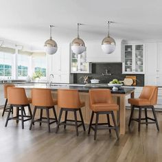 a large kitchen with an island and bar stools