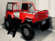 a red toy truck bed in the corner of a room