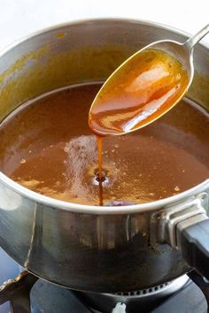 the sauce is being poured into the pot on the stove