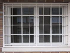 an open window on the side of a brick building with white trim and glass panes