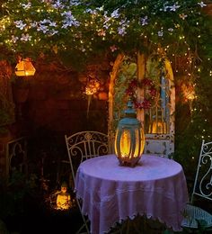 a table with a lit candle on it in the middle of an outdoor patio area