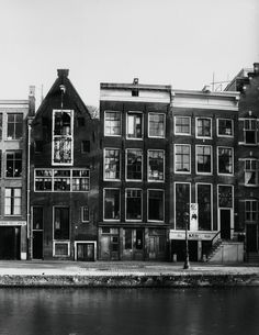 an old black and white photo of some buildings next to the water in front of them