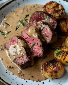 a plate with steak, potatoes and gravy on it