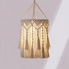 a hanging light with tassels and beads on the bottom is shown against a white background