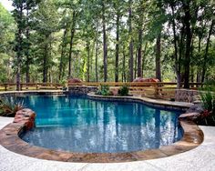 an outdoor swimming pool surrounded by trees