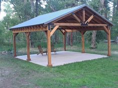 a wooden gazebo sitting on top of a lush green field