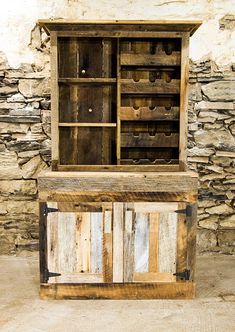 an old wooden cabinet sitting in front of a stone wall