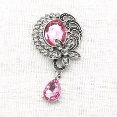 a pink and silver broochle on a white background