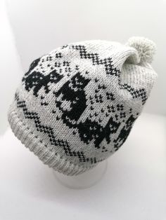 a white and black knitted hat sitting on top of a table