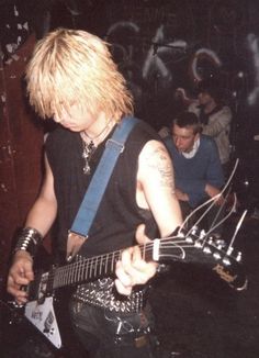 a man with blonde hair playing an electric guitar