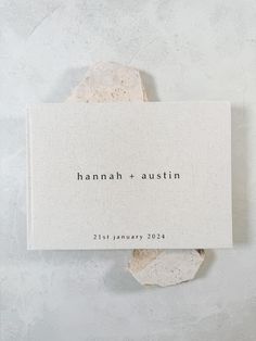 a piece of paper with the words hannah and austin on it sitting on top of a rock