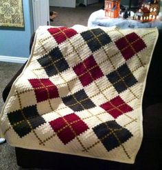 a crocheted blanket sitting on top of a couch