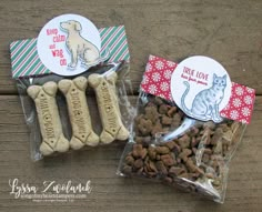 two bags of dog treats sitting next to each other on a wooden table with stickers