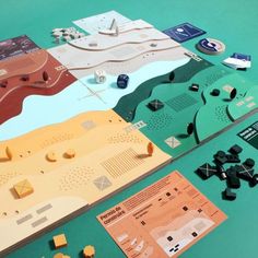 the board game is set up on a table with pieces of paper and other items