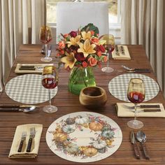 a table set with place settings and flowers in a vase on the centerpieces