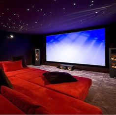 a red couch sitting in front of a large screen