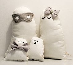 three pillows with eyes and noses are sitting next to each other in front of a white wall