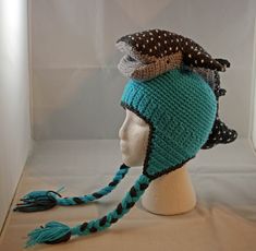 a knitted hat with braids on top of a mannequin head