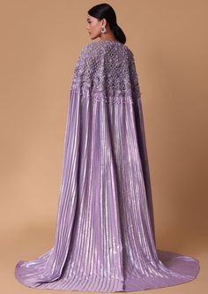 Indulge in elegance with our lilac foil print pleated cape & draped skirt set. The lilac foil print adds a touch of glamour to the flowing pleated cape effortlessly draping over your shoulders for an ethereal effect. Whether you're attending a special occasion or seeking to make a statement at a soirée this ensemble promises to turn heads and leave a lasting impression. Dry clean only if required. Slight variation in color is possible due to digital photography. Unholy Matrimony, Siren Costume, Cape Dresses, Great Comet Of 1812, The Great Comet, Kaftan Designs, Embellished Skirt, Purple Dresses, Fashion Gowns