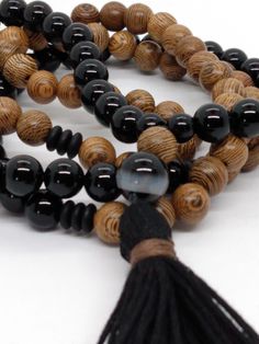 A lovely mala made up of a combination of 8mm Black Onyx and Wenge wood  beads, with black donut spacer beads and a handmade tassel. Black Onyx makes this a powerful protection mala that brings with it calm, peace, and inner strength. It is especially protective during times of spiritual exploration. The striping of the exotic Wenge wood is a beautiful accent that supports the properties of the Black Onyx. Wishing you love, peace, and infinite blessings. * Mala beads, also known as prayer or med Traditional Black Beaded Bracelets For Meditation, Black Beaded Bracelet With 108 Beads For Meditation, Black Bohemian Beaded Bracelets For Meditation, Black Wooden Beads For Meditation, Black Spiritual Beads For Meditation, Black Holistic Beaded Bracelets, Traditional Black Mala With 8mm Beads, Traditional Hand-strung Black Mala, Traditional Black Wooden Beaded Bracelets