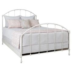 a white metal bed frame with pillows on it