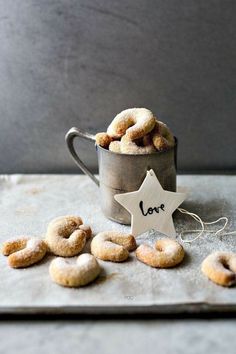 doughnuts in a metal cup with a star shaped love sign next to them