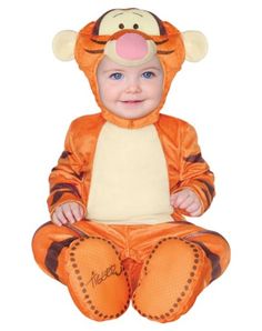 a baby dressed in an orange winnie the pooh costume sitting on top of a white floor