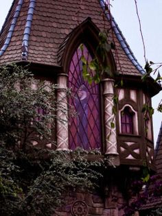 an old building with a stained glass window in the middle of it's roof