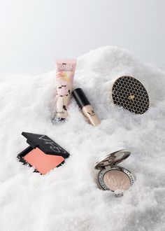 various makeup products are laying on the snow