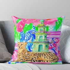 a colorful pillow on a couch with a painting of a leopard and a building in the background