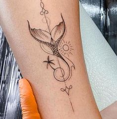 a woman's leg with a tattoo on it and an arrow in the middle