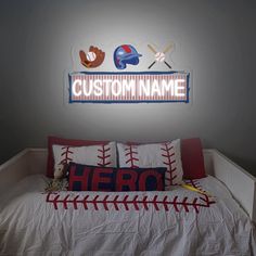 a baseball themed bedroom with custom name sign above the bed