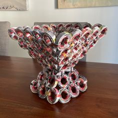 a sculpture made out of magazines sitting on top of a wooden table