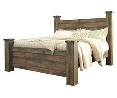 a wooden bed with white sheets and pillows