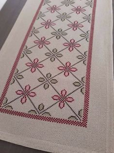 a cross stitched table runner with flowers on it