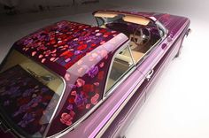 an old purple car with hearts painted on it