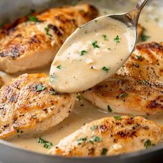 a spoon is being used to scoop some chicken out of the pan with gravy