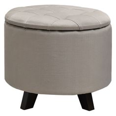 a round ottoman with wooden legs and a buttoned up seat on the top, in grey