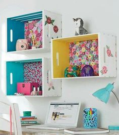 a desk with a laptop computer on top of it next to a wall mounted shelf