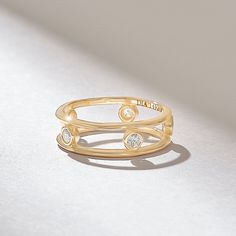 a gold ring with two diamonds on it