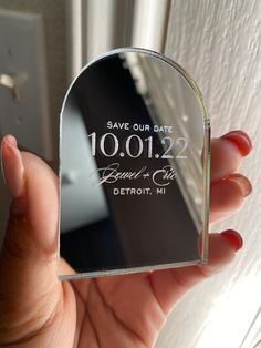 a person holding up a glass save our date magnet