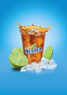 a glass filled with ice and limes next to an iced drink on a blue background